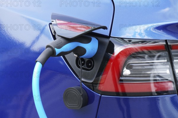 EV or Electric car at charging station with plug-in power supply cable - e-mobility concept