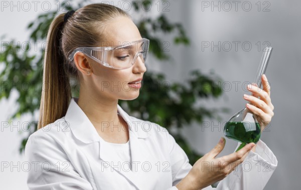 Side view female researcher with test tube safety glasses