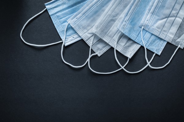 Disposable protective sterile masks on black background