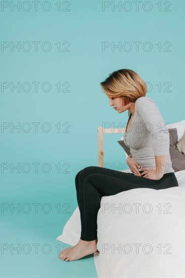 Woman sitting with hurting stomach