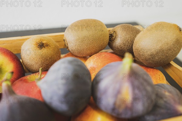 Apples, kiwi and fig in a wooden fruit basket as a healthy meal, Hanover, Lower Saxony, Germany,