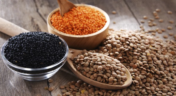 Composition with three sorts of lentils on wooden table