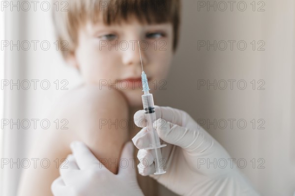 Doctor with gloves getting vaccine kid