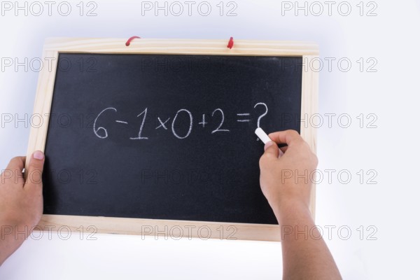 Hand writing a math problem on board with a chalk