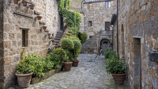 Old tufa buildings decorated with flowers in the hilltop village of Civita di Bagnoregio, Lazio,