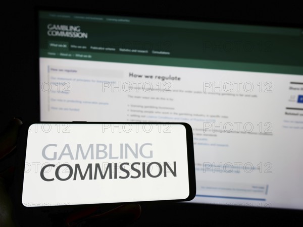 Stuttgart, Germany, 04-01-2023: Person holding smartphone with logo of British public body Gambling