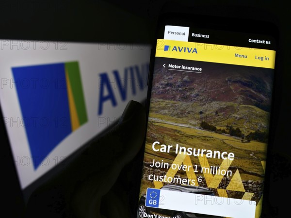 Stuttgart, Germany, 11-30-2022: Person holding smartphone with website of British insurance company