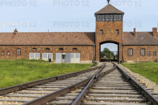 Auschwitz, Poland - 15 September, 2021: view of the gatehouse and train tracks at Auschwitz