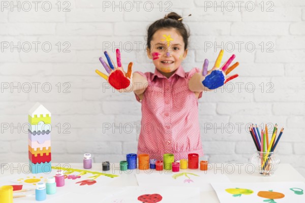 Smiling portrait girl showing her painted colorful hand camera