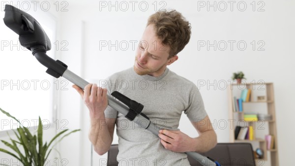 Man with vacuum cleaning house