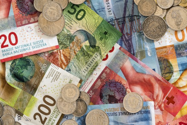 Swiss franc coins and bank notes in different denominations close up view