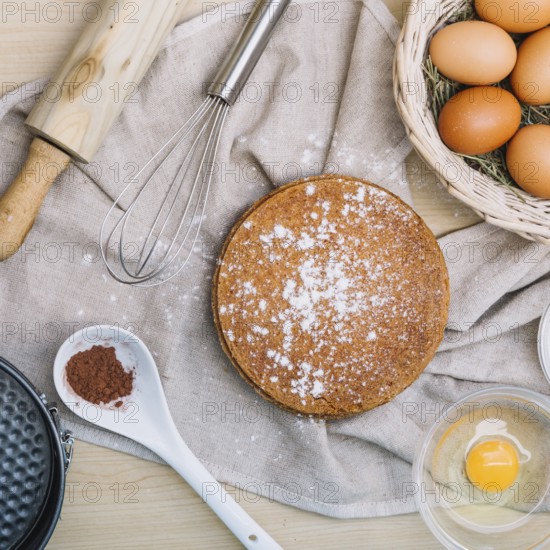 Sponge cake with icing sugar ingredients wooden table