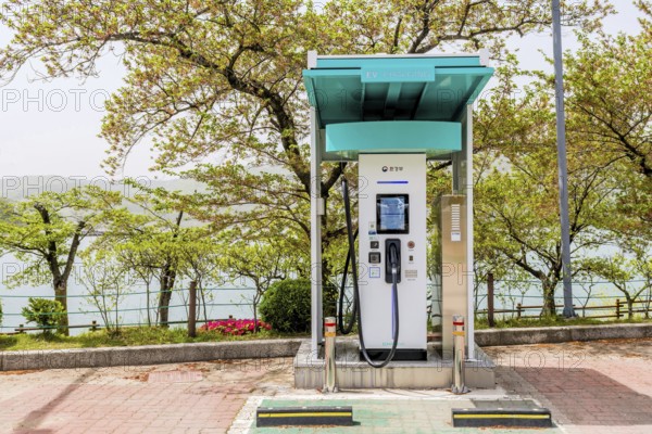 An electric vehicle charging station located by a lake with trees around, in Suncheon, South Korea,
