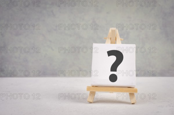 Question mark on an easel, education and business concept, searching for answers, thoughts for