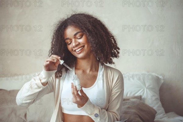 Beauty and skincare concept. Cropped photo of african american young female model holding bottle