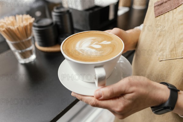 Side view female barista holding decorated cup coffee hands