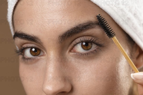 Young woman taking care her eyebrows