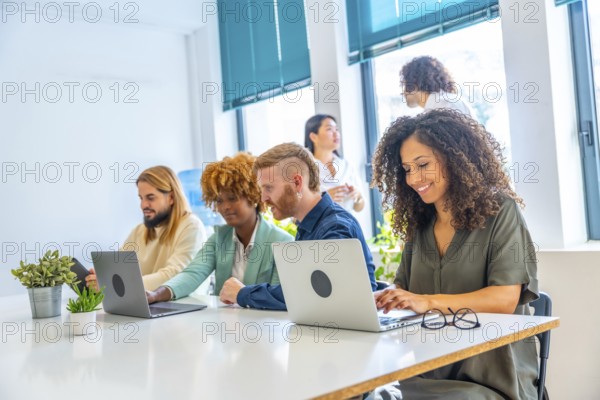 Dynamic side view of man and woman sitting in a coworking using laptop