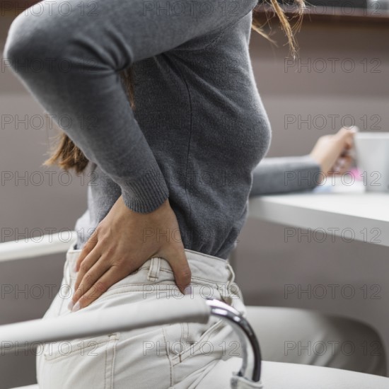 Sideways woman having backache while working from home