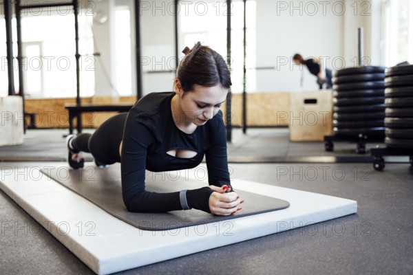 Young beautiful woman stretching and warming up before workout in fitness gym, Sport and healthcare