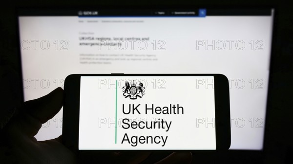 Stuttgart, Germany, 05-26-2022: Person holding cellphone with logo of agency UK Health Security