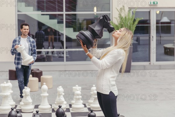 Girl kissing chess horse by chess board