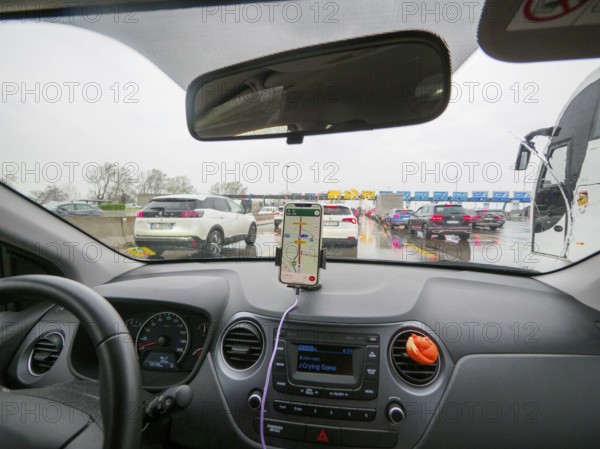 Inside view of a car with navigation on, stuck in traffic on a cloudy day, A1 A8 highway near