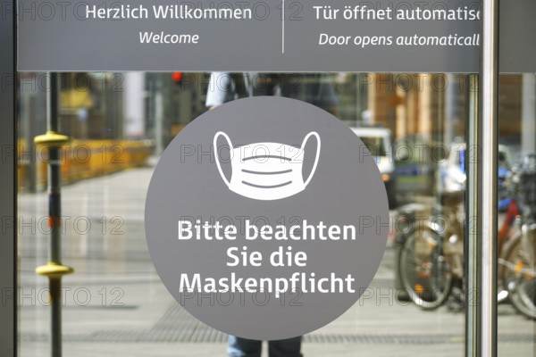 Hannover, Germany - May 21, 2020: German language sign on entrance door to shopping center advises
