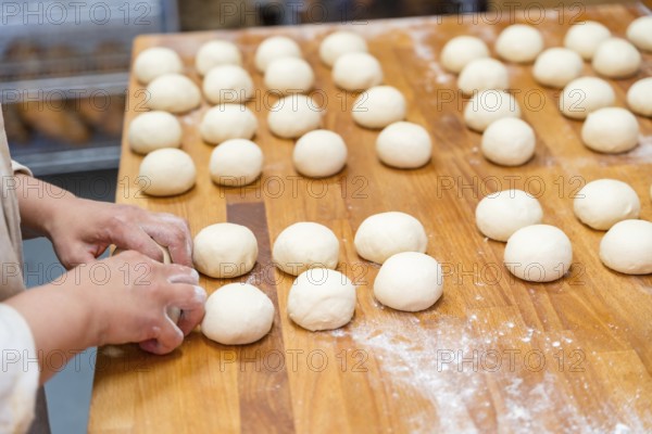 Hands of female baker in the bakery workshop of artisan bakery preparing the bread dough