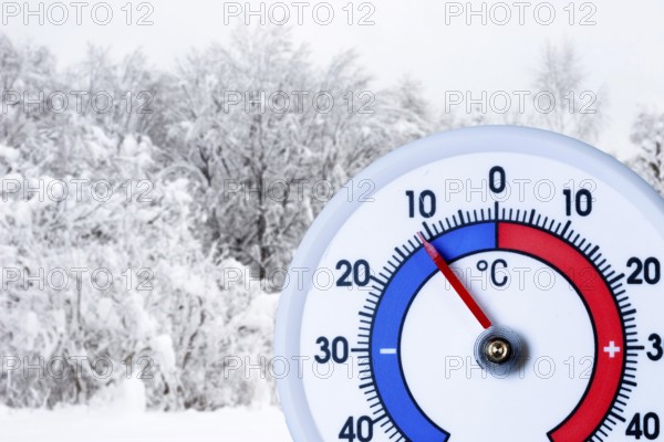 Thermometer below minus ten degrees Celsius, snow-covered bushes and trees