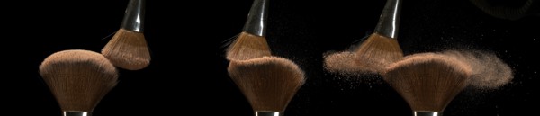 Make-up Brush spreading blush powder on black background
