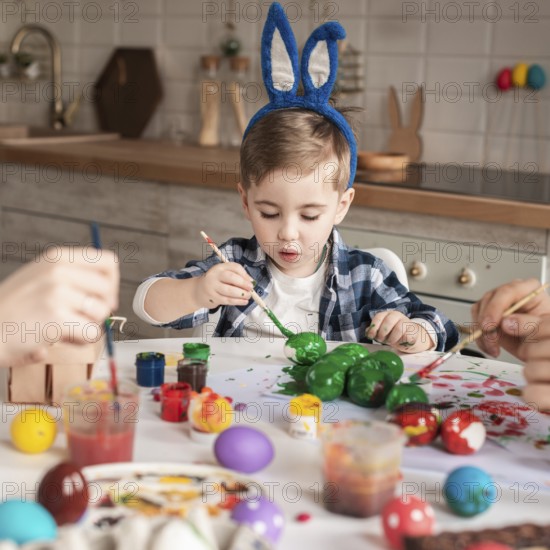 Cute little boy painting traditional eggs easter