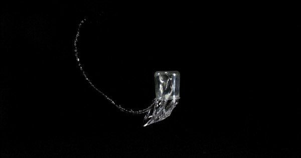 Glass of Water Bouncing and Splashing on Black Background