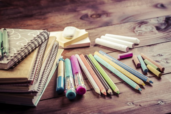 School supplies with exercise book and notepads on wooden background. Back to school concept