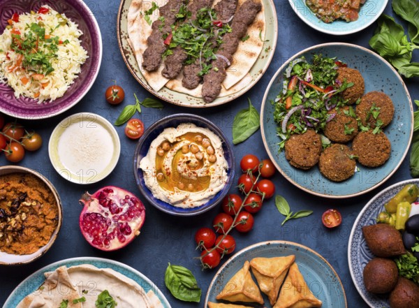 Middle eastern or arabic dishes and assorted meze, concrete rustic background. Meat kebab, falafel,
