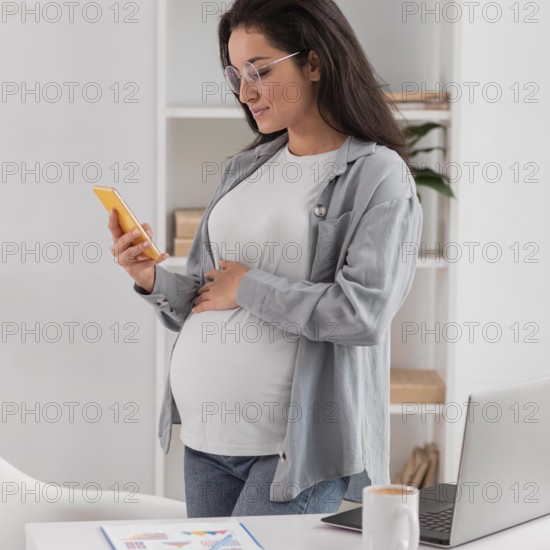 Side view pregnant woman home with laptop smartphone