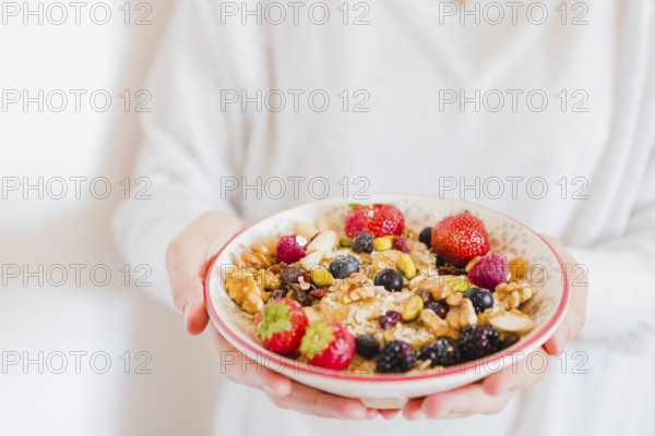 Crop person holding bowl oatmeal