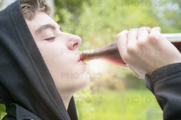 Young man with hoodie drinking a cola