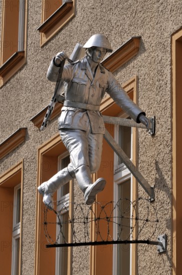 Jumping soldier, barbed wire, house wall, sculpture Jump, by Conrad Schumann, Wall memorial,