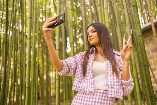 Young caucasian girl with a pink skirt in a bamboo forest. Enjoying summer holidays in a tropical