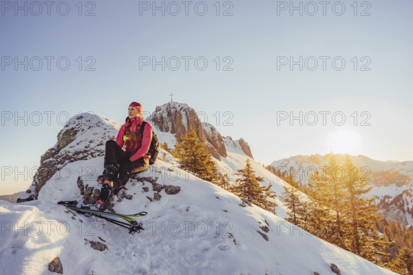 A woman's ski tour at sunrise on the Tegelberg in the Allgäu in the Ammergebirge, Bavaria, Germany,