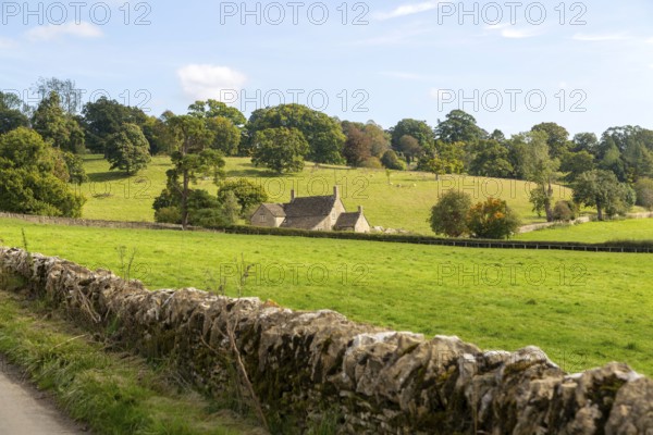 Cotswolds landscape of fields, trees, farmhouse building, near Yanworth, Gloucestershire, England,