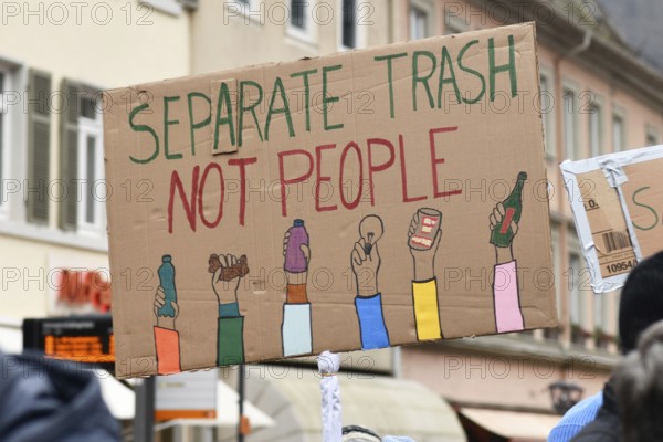 Heidelberg, Germany - February 12th 2025: Person holding up sign with text 'Separate trash not