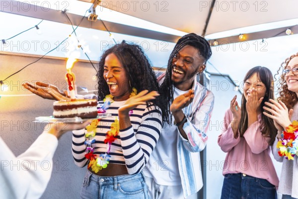 Multiracial young group of friends at terrace together celebrating with sparkling lights a summer
