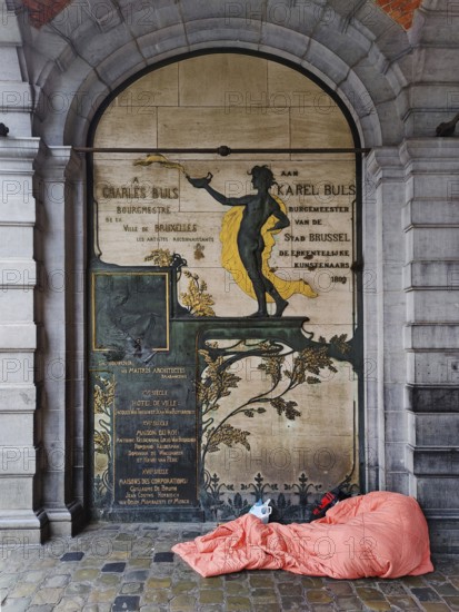 Homeless person in front of a façade detail at the L'Étoile guildhall, Grand-Place, Grote Markt,