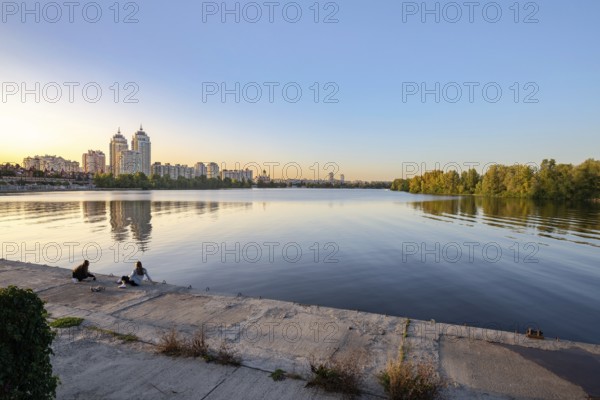 Ukraine, September 22, 2020, Two girls on the embankment close to the high Obolon buildings near
