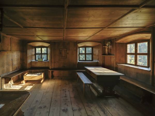 Farmhouse parlour with a small house altar in the dining corner and a baby cot, open-air museum