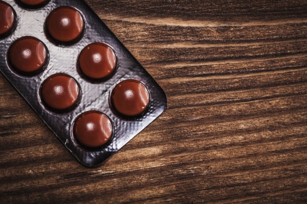 Blister pack with pills on vintage wooden board
