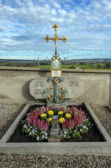 Grave with heather (Erica), near St George and St Florian, a listed Catholic parish church in
