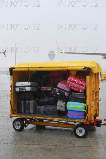 Baggage with baggage tag with control tower during thunderstorm, heavy rain, rain cloud, storm,